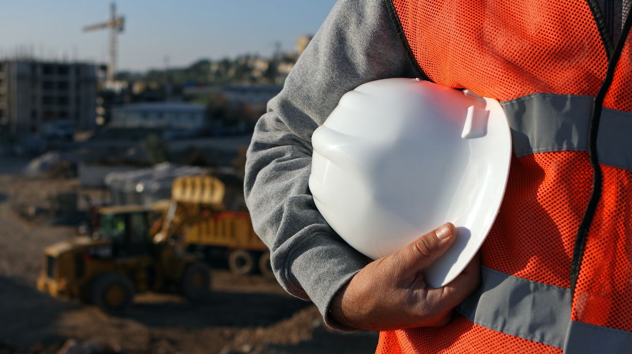 Construction worker holding a white hard hat