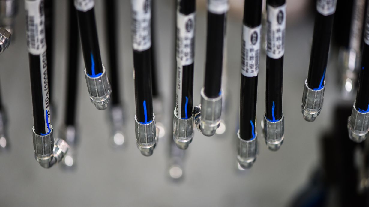 Black hydraulic hoses with labels on a rack