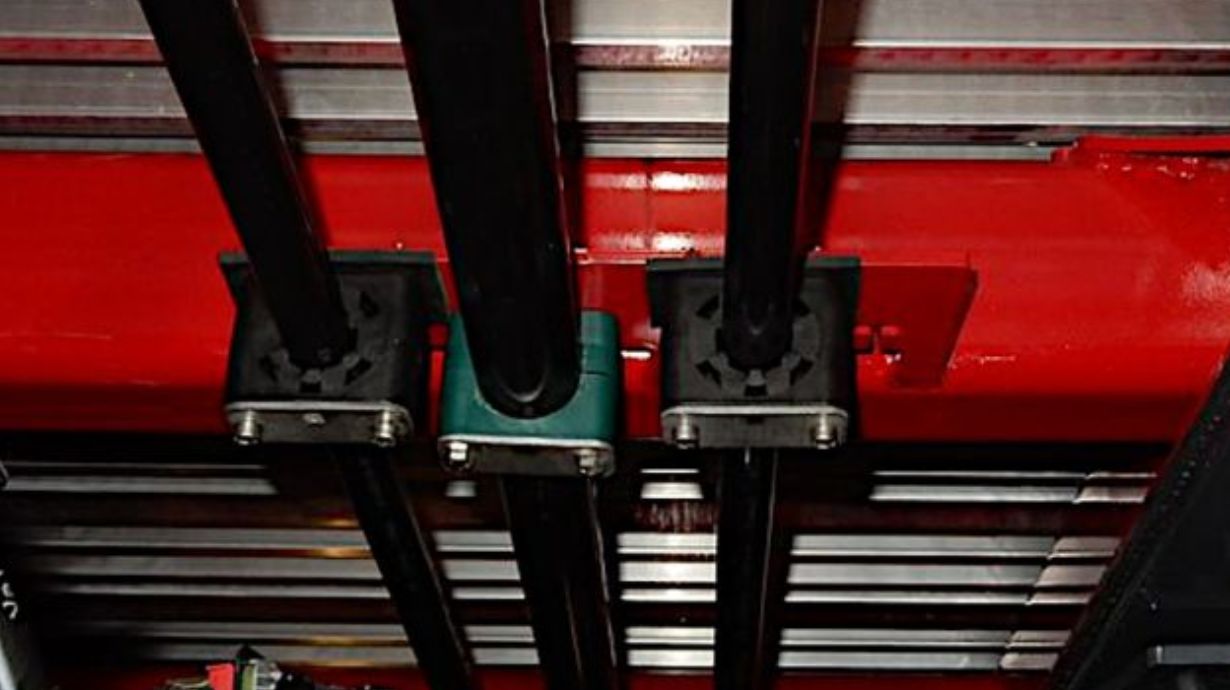Three STAUFF plastic tube line clamps installed on a red post